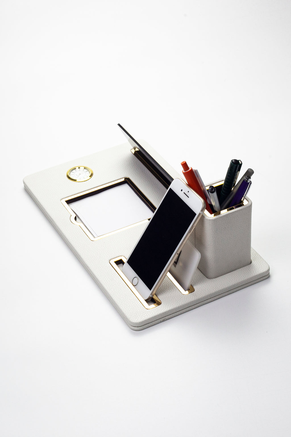 لوحة اسم مكتبية من الجلد، منظم مكتب، ساعة ذهبية بيضاء مزينة بتفاصيل، حامل أقلام.